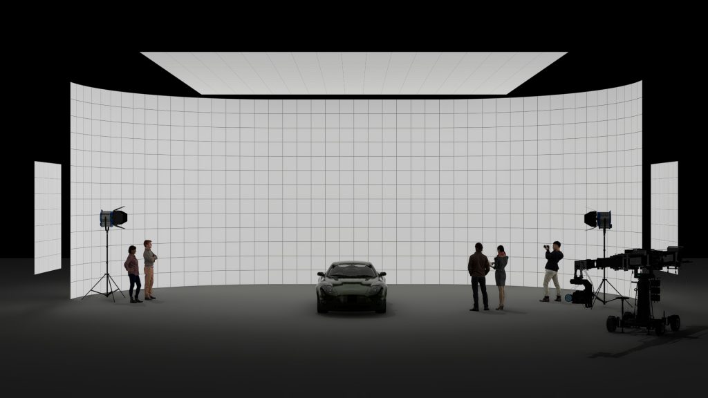 Green sports car on a high-tech virtual production LED volume stage with film crew, lighting, and camera equipment.